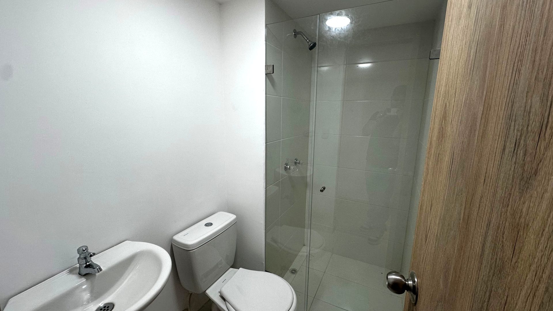 Baño terminado con lavamanos, inodoro y ducha en vidrio