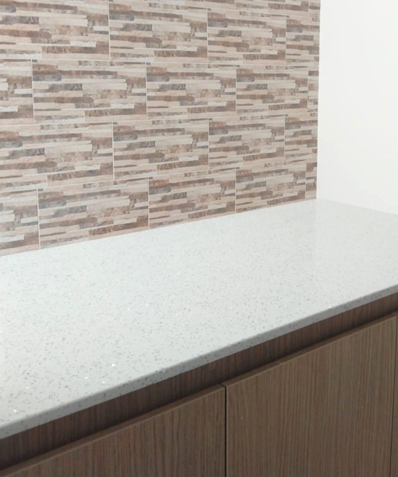 Mesón de piedra y enchape en la cocina terminada de la obra blanca