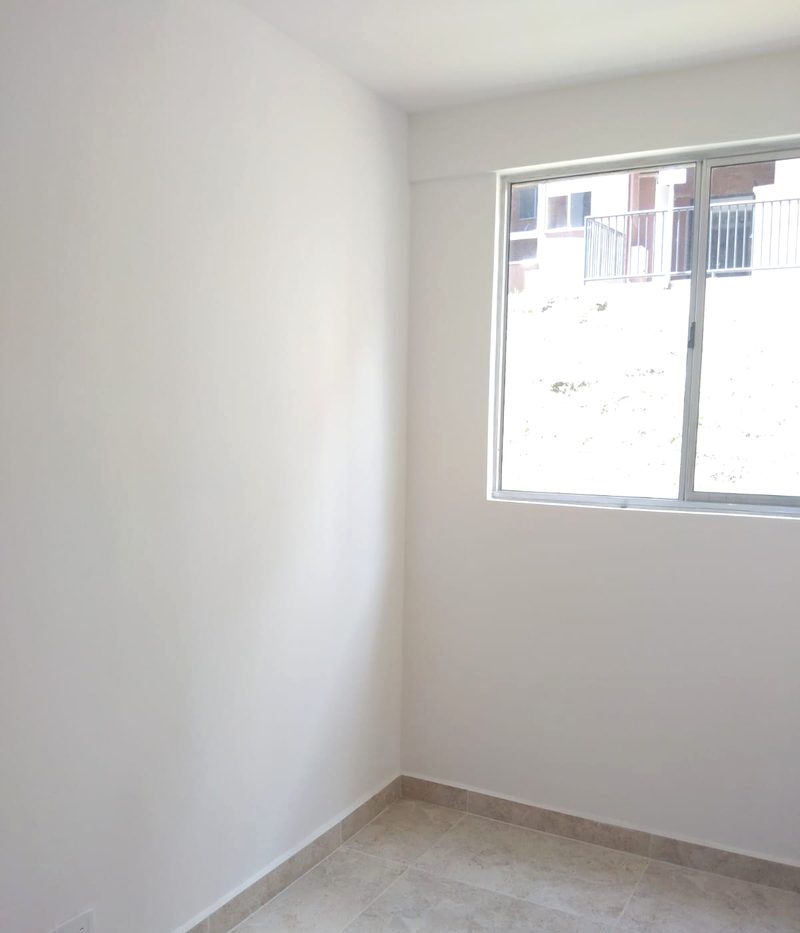 Sala terminada con muros blancos y piso en porcelanato